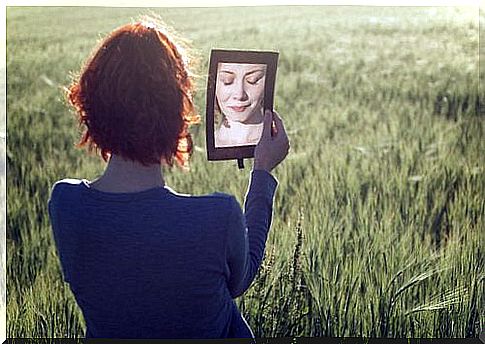 woman with eyes closed in front of a mirror