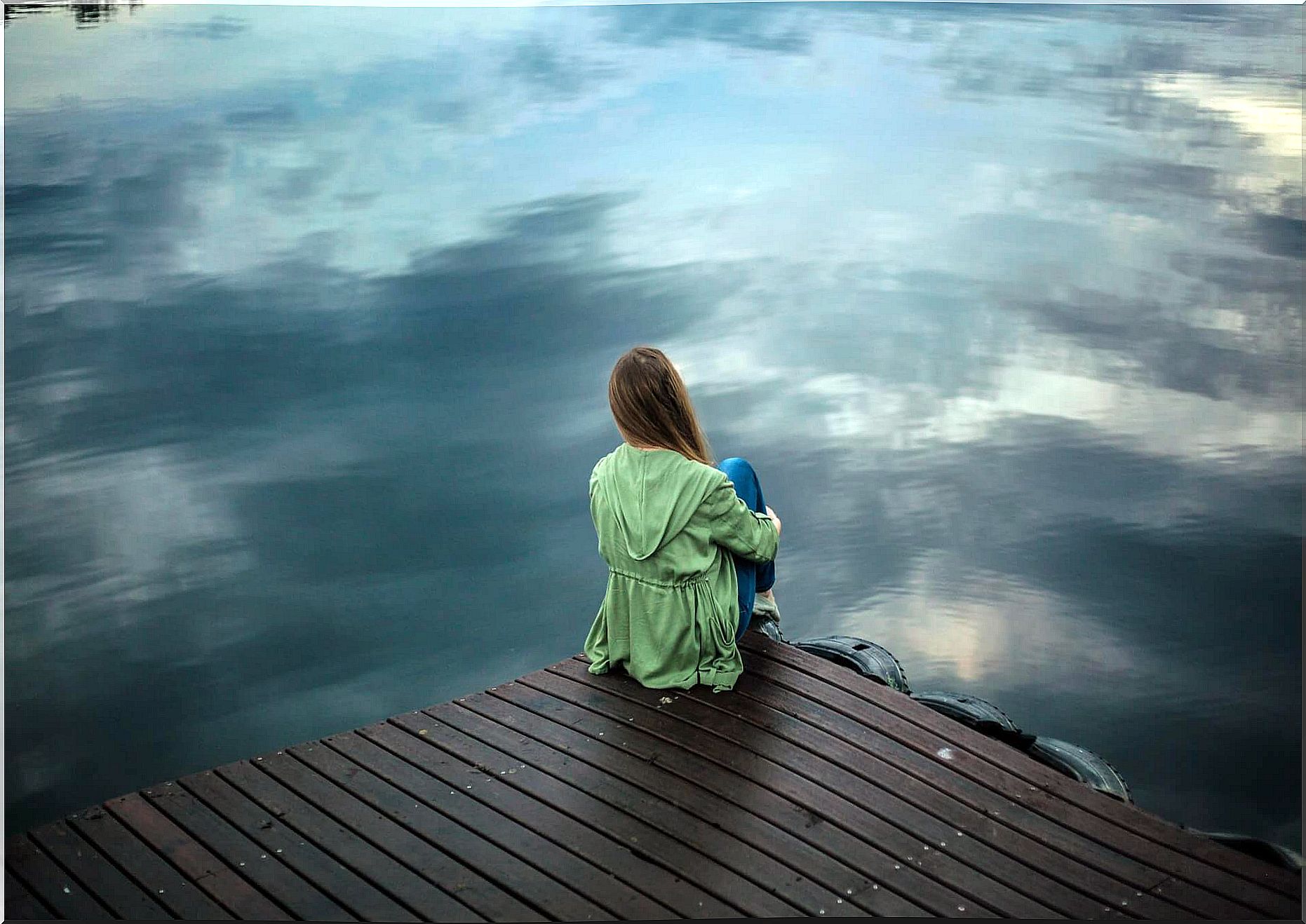 thoughtful woman in front of lake