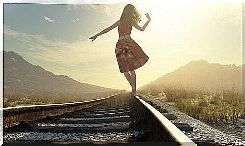 Woman on a train track reflecting to make the right decision