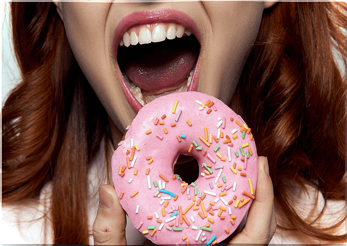 Woman eating donuts full of sugar