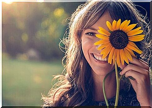 woman smiling with sunflower